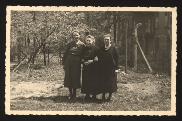 Front shows three elderly women standing together in a garden/courtyard with trees and buildings in the background. One of them is identified as "Else," dated 1950.