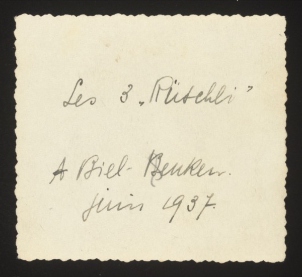 ANNOTATION ON PHOTO (back, handwritten): French/Swiss German: "Les 3 'Rübchli' A Biel-Benken. Juin 1937." English: "The 3 'little turnips' At Biel-Benken. June 1937." Note: "Rübchli" is Swiss German diminutive of "Rübe" (turnip) — an affectionate nickname for three children. Biel-Benken is a village in the canton of Basel-Landschaft, Switzerland, near Basel. The French/Swiss-German mix confirms a Basel-area family connection. The front shows three children.