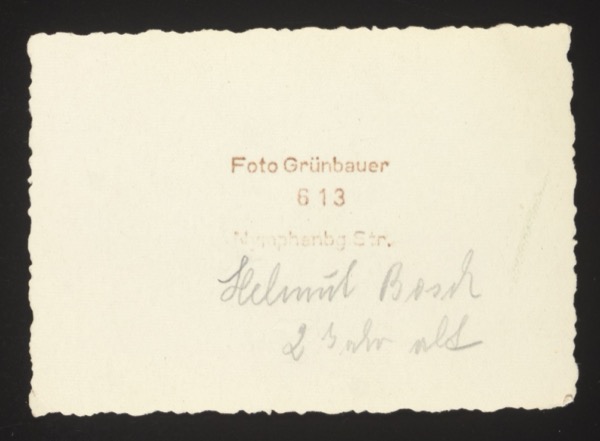 ANNOTATION ON PHOTO (back, printed and handwritten): Printed: "Foto Grünbauer, 613 Nymphenbg. Str." Handwritten: "Helmut Bosch. 2 Jahre alt." Description: Second photo of Helmut Bosch at age 2, same studio session as photo 0027.